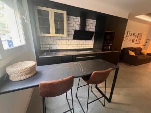 a kitchen with a black table and two chairs at Jacuzzi & Relax Almería Juzgados in Almería
