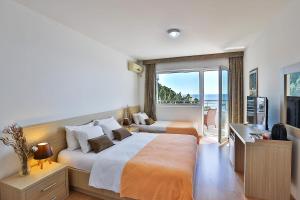 a bedroom with a large bed and a balcony at Kolomat in Sveti Stefan