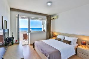 a bedroom with a bed with a view of the ocean at Kolomat in Sveti Stefan