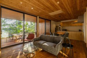 a living room with a couch and a table at ガーデンヴィラ白浜　KOTI in Shimoda