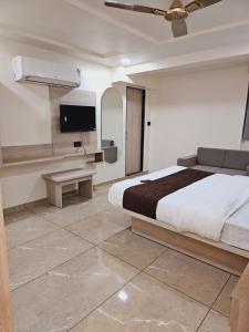 - une chambre avec un lit et une télévision à écran plat dans l'établissement HOTEL R K VILLA, à Ahmedabad