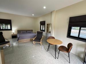 a bedroom with a bed and a table and chairs at Vergers de Nil les lauriers in Ban Chawuk +61 photos