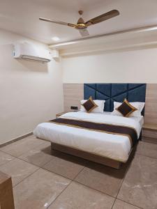 1 dormitorio con 1 cama grande y ventilador de techo en HOTEL R K VILLA en Ahmedabad