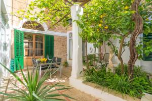 un patio al aire libre con mesa y árboles en Ca sa Tia Bel, en Alcudia