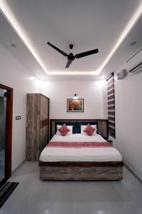a bedroom with a bed with a ceiling fan at The Oscar Grand in Lucknow