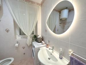 a white bathroom with a sink and a mirror at Seafront apartment with amazing view in Jezera