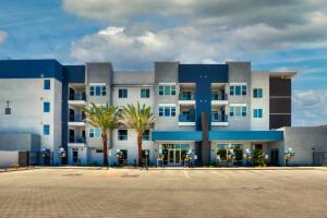 a large building with palm trees in front of it at Stunning Westgate CozySuites by stadium with pool 12 in Glendale