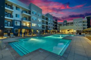 a large swimming pool in front of a apartment building at Stunning Westgate CozySuites by stadium with pool 12 in Glendale