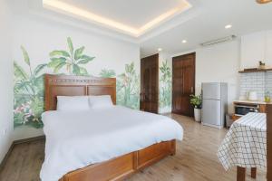 a bedroom with a large bed and a kitchen at LUCK APART 03 - Tay ho Center Garden View Studio! in Hanoi