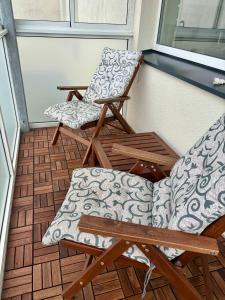 2 Stühle und ein Tisch auf einer Veranda in der Unterkunft City Park Apartment in Vilnius