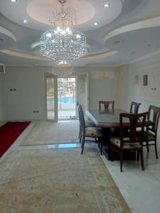 a dining room with a table and chairs and a chandelier at Pyramids and Museum Resort /villa in Giza