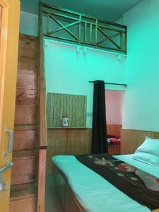 馬拉里的住宿－iSaint's Kuteer，一间卧室配有一张双层床和绿色的床罩