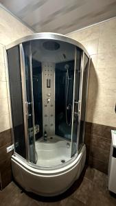 a shower in a bathroom with a large mirror at Просторный дом в элитном районе Тбилиси in Okrokana