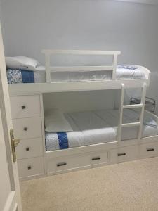 a white bunk bed with white drawers and a door at vistas desde montequinto in Dos Hermanas