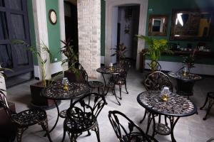 un grupo de mesas y sillas en una habitación con plantas en Casa Maria Jimena Hotel Boutique, en Chihuahua
