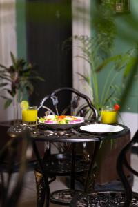 una mesa con dos platos de comida y dos vasos de zumo de naranja en Casa Maria Jimena Hotel Boutique, en Chihuahua