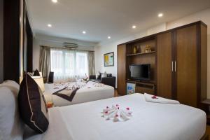 a hotel room with two beds and a television at Splendid Holiday Hotel Spa in Hanoi