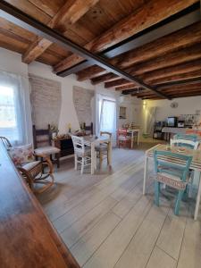 a living room with wooden floors and a table and chairs at La Corte di Rosa in San Vito al Tagliamento