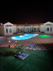 uma grande piscina num quintal à noite em Mountains resort by escape time em Fujairah