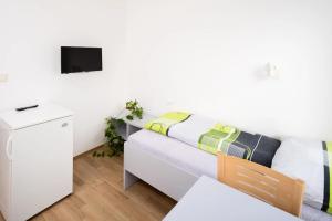 a living room with a white couch and a tv at Penzion a ubytovna Oáza in Otrokovice