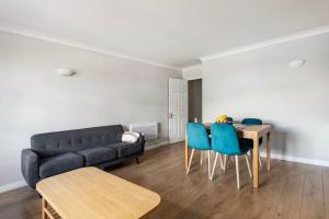 een woonkamer met een bank en een tafel en stoelen bij Beautiful 2 bed / 2 bath flat near central London in Londen