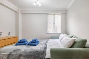 een slaapkamer met een bed met blauwe handdoeken bij Beautiful 2 bed / 2 bath flat near central London in Londen