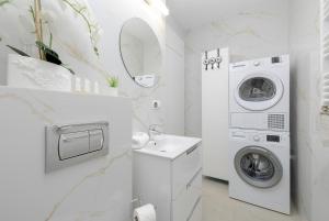 a white bathroom with a washing machine and a sink at Modern Apartment 1 Maja with Parking in Kołobrzeg by Rent like home in Kołobrzeg