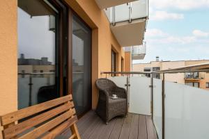 a chair sitting on the balcony of a building at Modern Apartment 1 Maja with Parking in Kołobrzeg by Rent like home in Kołobrzeg
