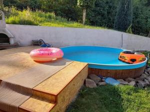a small swimming pool with a toy car in a backyard at Slnečná Chatka Vyhne in Vyhne