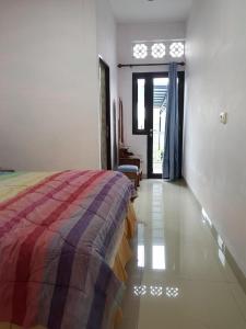 a bedroom with a bed and a room with a window at Villa Mawar Bumi Citeko in Bogor