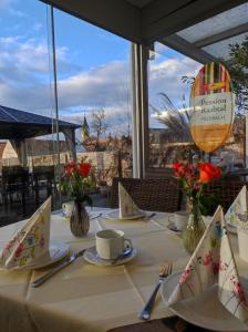 - une table avec des assiettes et des ustensiles en haut dans l'établissement Hotel & Frühstückspension Raabtal, à Feldbach