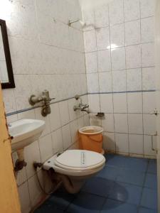 a bathroom with a toilet and a sink at Hotel Cozy Residency in Jabalpur