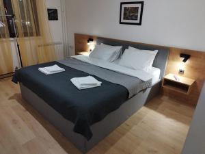 a bedroom with a large bed with two towels on it at Home apartment in Niš