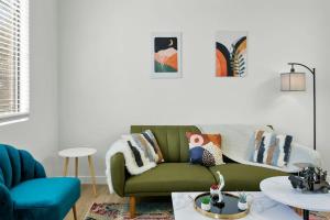 a living room with a green couch and a table at CozySuites Glendale by the stadium with pool 08 in Glendale