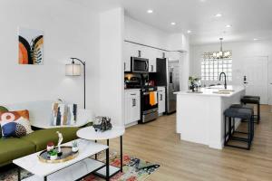 a living room with a green couch and a kitchen at CozySuites Glendale by the stadium with pool 08 in Glendale +26 photos