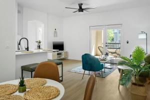 a living room with tables and chairs and a kitchen at CozySuites Glendale by the stadium with pool 02 in Glendale +29 photos