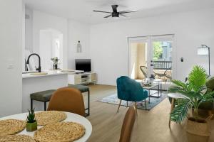 a living room with tables and chairs and a kitchen at TWO Glendale CozySuites with Pool & Jacuzzi 02&09 in Glendale +37 photos