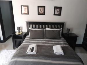 uma cama com duas toalhas e um controlo remoto em Robert's Place Paarl em Paarl