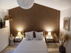 - une chambre avec un grand lit et deux lampes dans l'établissement La MARTELLERIE, à Berville-sur-Seine