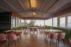 a dining room with tables and chairs and windows at Super Hotel by Perfectstayz Mall Road in Mussoorie