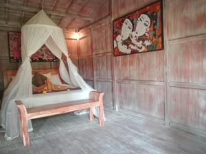 Zimmer mit einem Bett und einer Bank in der Unterkunft Wooden House and Spa Ubud in Ubud