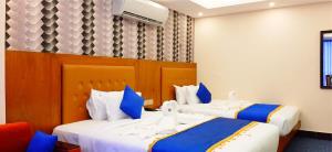 2 letti in una camera d'albergo con blu e bianco di New Hotel Grand View a Sylhet