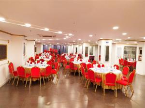 una sala banchetti con tavoli e sedie rosse di New Hotel Grand View a Sylhet