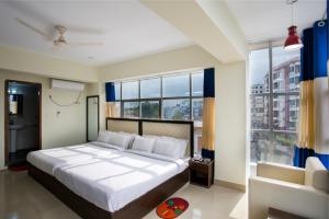 una camera con un grande letto e una grande finestra di New Hotel Grand View a Sylhet