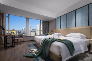 a hotel room with two beds and a desk at Echarm Hotel - Beijing Road Pedestrian Street Sky Pier in Guangzhou