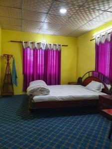 a bedroom with pink curtains and a bed in a room at Dadaghare Homestay & View Point Restaurant in Panauti