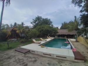 una piscina con tumbonas en un patio trasero en Gita Gili Bungalow, en Gili Air