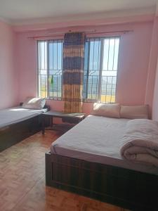 a room with two beds and two windows at Namobuddha Hotel n Lodge in Dhulikhel