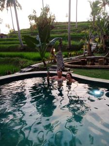 zwei Personen in einem Schwimmbad in einem Resort in der Unterkunft Wooden House and Spa Ubud in Ubud
