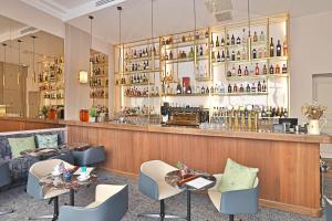 a restaurant with a bar with tables and chairs at Negrecoste Hôtel & Spa in Aix-en-Provence
